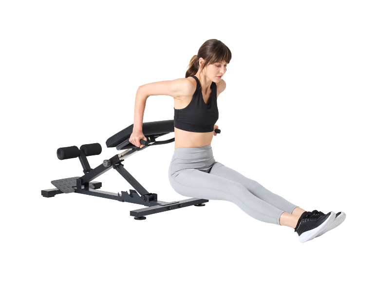 Žena izvodi propadanja za triceps na klupi za vježbanje.