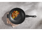 Wok s prženim povrćem i tofuom na cementnoj pozadini.