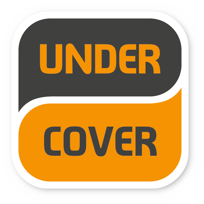 Značka s tekstom „UNDER COVER“ u narančastoj i sivoj boji.