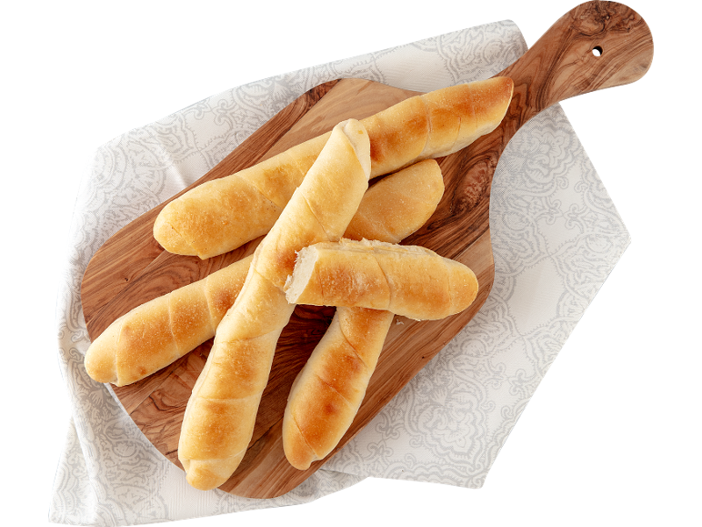 Peciva na drvenoj dasci s bijelom krpom.
