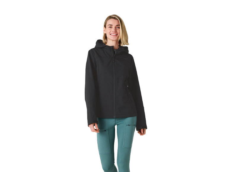Nasmijana žena u crnoj softshell jakni i tirkiznim sportskim hlačama