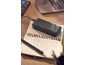Crni power bank puni se na otvorenoj bilježnici s olovkom, laptop u pozadini.