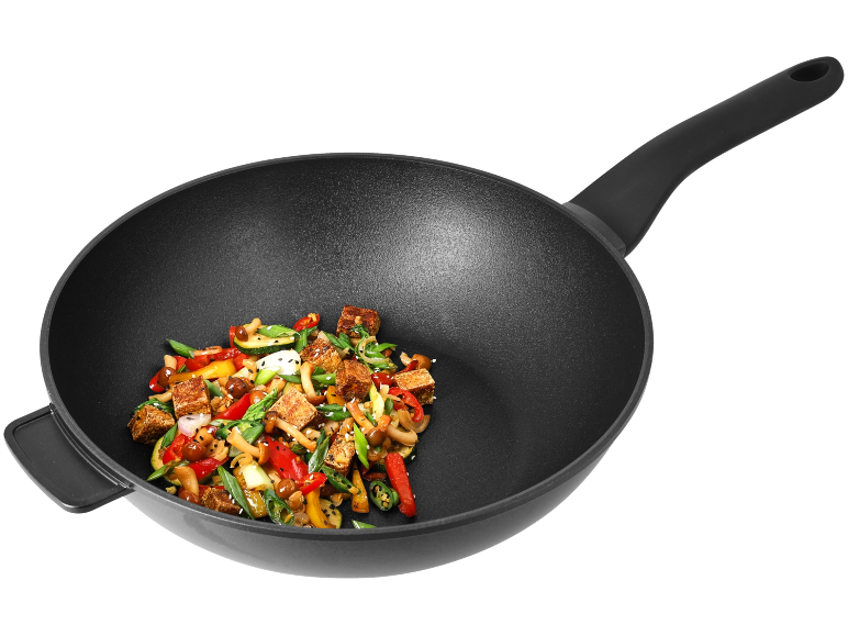 Wok s prženim povrćem i tofuom, s crnim ručkama, na crnoj pozadini.