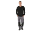 Muškarac u crnoj majici dugih rukava i sivim radnim hlačama.