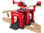 Crvena igračka vatrogasne postaje s helikopterom, vlakom i drvenim tračnicama, s natpisom 'FIRE DEPT'.