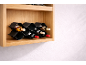 Drvena polica s crnim valovitim stalkom za vino s šest boca.