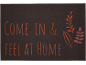 Tamnosmeđi otirač s tekstom 'COME IN & FEEL AT HOME' i ukrasnim lišćem.