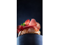 Bruschetta s pršutom i svježim začinskim biljem na tamnoj pozadini.
