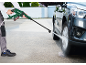 Muškarac čisti automobil bežičnim visokotlačnim peračem.