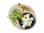 Kocke feta sira sa svježim origanom i nasjeckanim mladim lukom na drvenoj dasci.