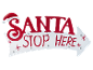 Bijela svjetleća strelica s crvenim natpisom „SANTA STOP HERE“ i božićnom kapom.