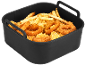 Košara friteze na vrući zrak ispunjena zlatnim pomfritom, kolutićima luka i pohanim komadima piletine.