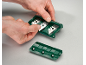 Ruke umeću zamjenske oštrice u zeleni strugač za staklo.