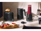 Crni toster, kuhalo za vodu i blender sa smoothiejem na kuhinjskom pultu.