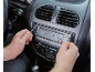 Muškarac instalira auto radio u kontrolnu ploču vozila.