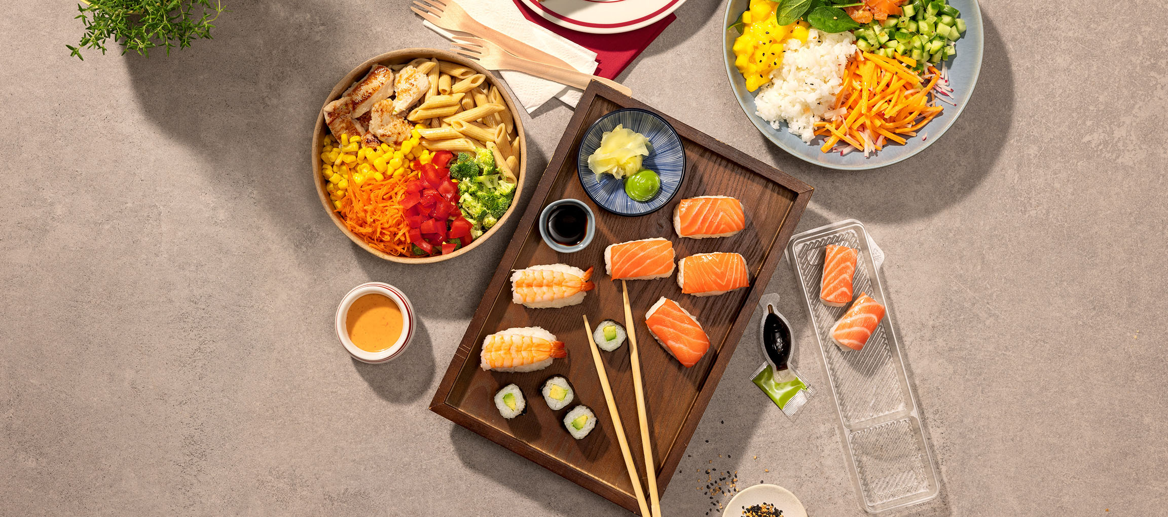 Raznovrsna jela: zdjela s tjesteninom i piletinom, sushi i poke zdjela na stolu.