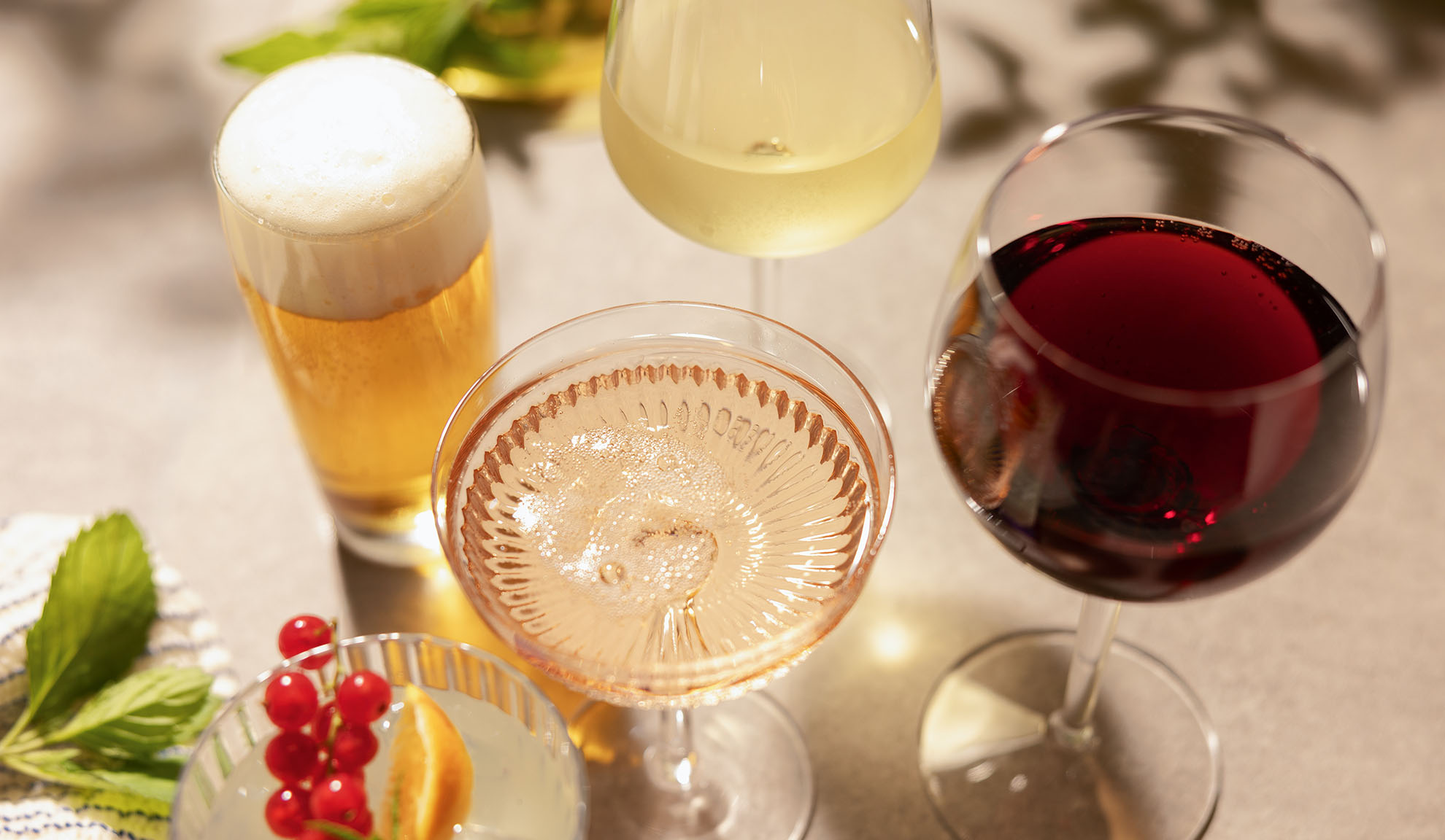 Čaše piva, bijelog, rosé i crnog vina, s koktelom i bobicama.