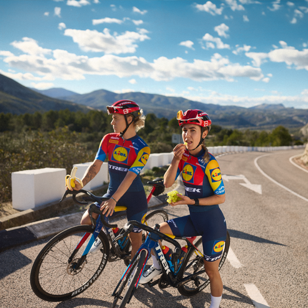 Dvije biciklistice iz tima Trek-Segafredo Lidl uživaju u pauzi s voćem.