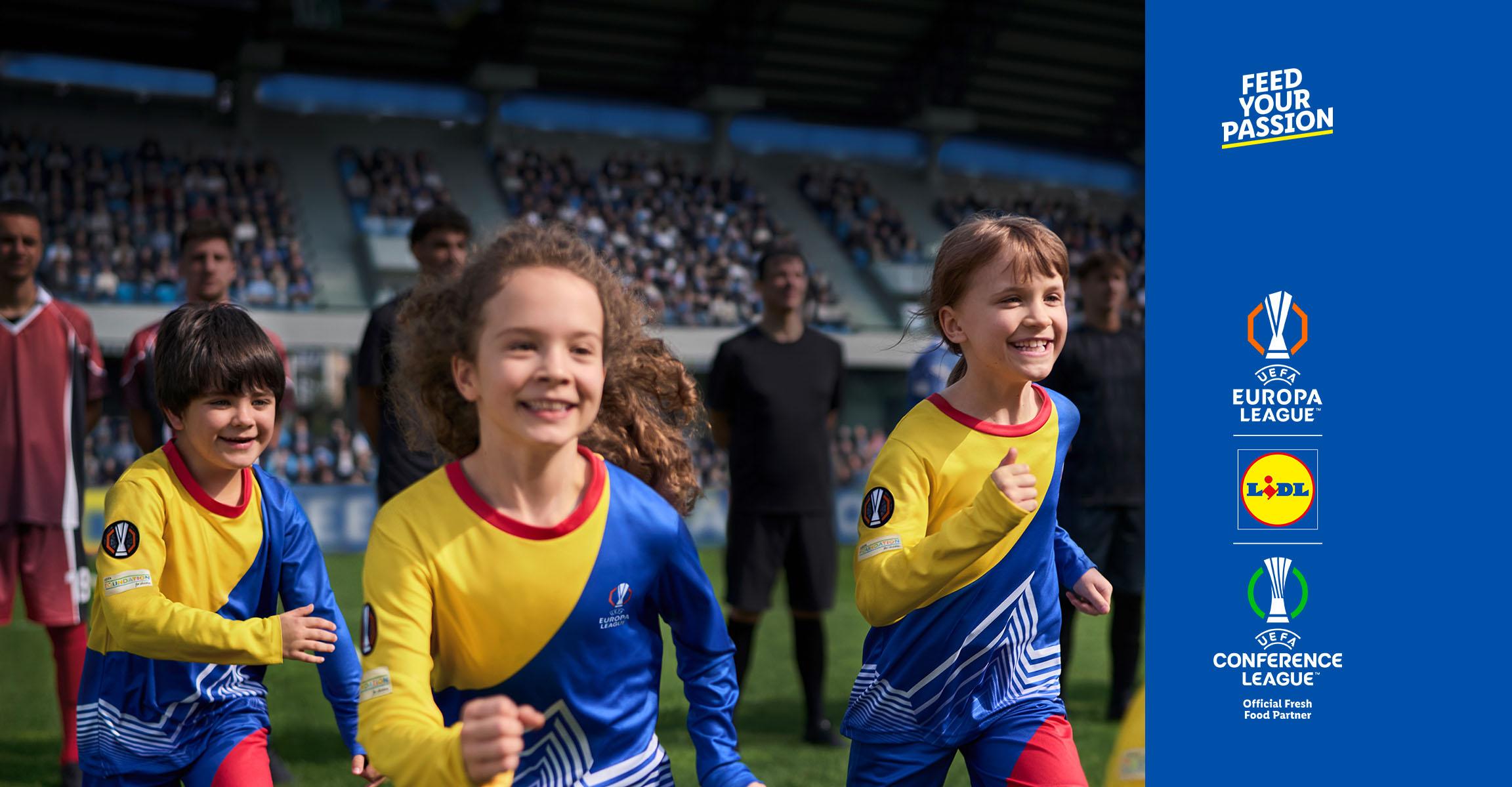 Nekoliko nasmijane djece u žuto-plavim dresovima trči naprijed na nogometnom stadionu.