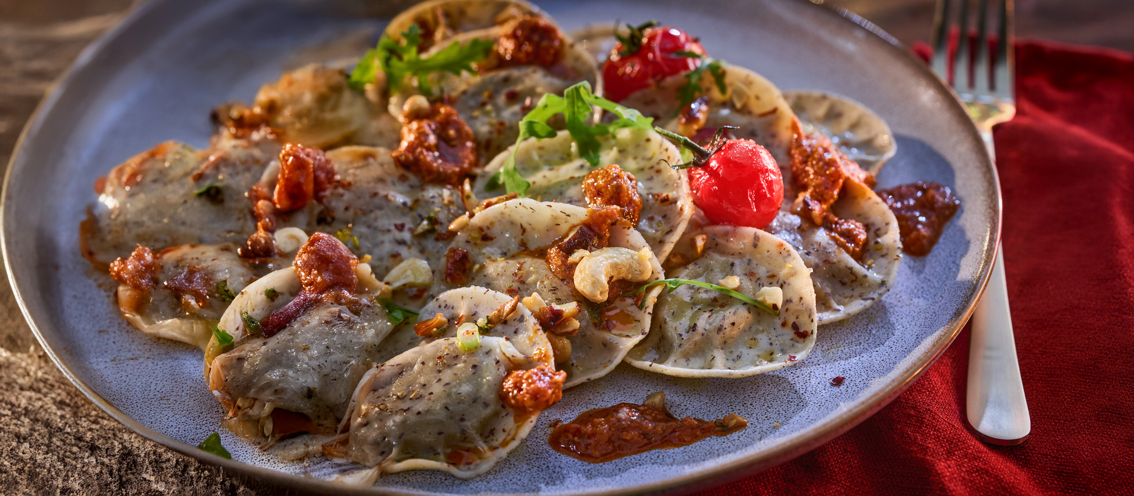 Tanjur raviola s umakom od rajčice, indijskim oraščićima i cherry rajčicama.