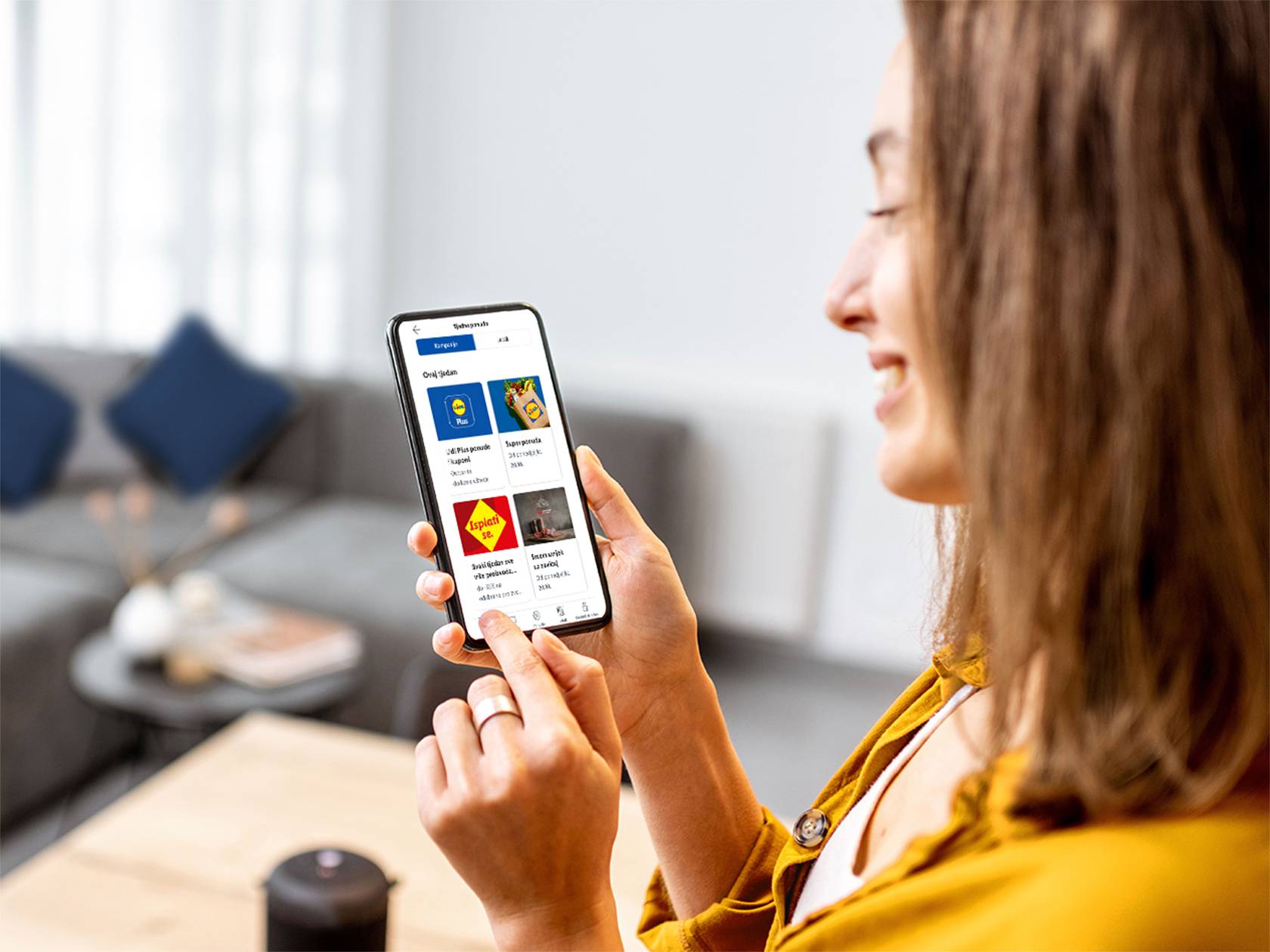 Žena pregledava Lidl Plus ponude i superponude na svom pametnom telefonu.