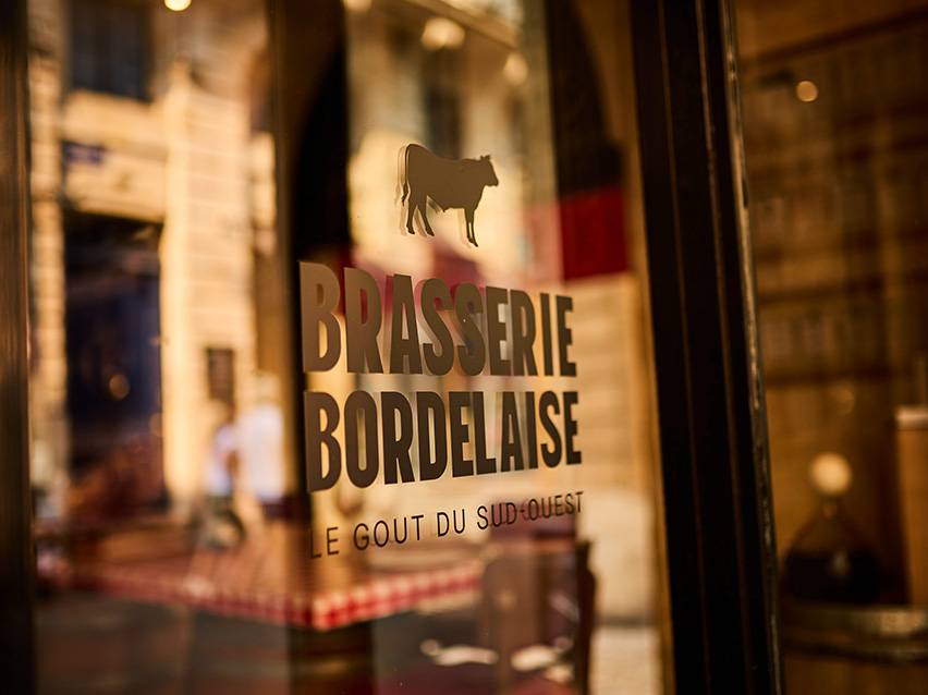 Natpis Brasserie Bordelaise sa siluetom krave i tekstom „Le Goût du Sud-Ouest“.