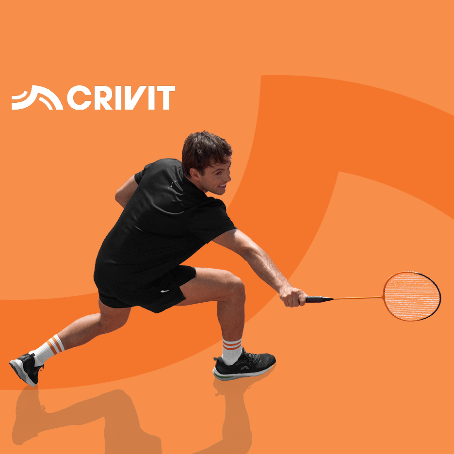 Muškarac u crnoj sportskoj odjeći igra badminton s narančastim reketom.