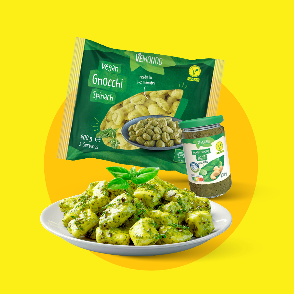 Pakiranje veganskih njoka od špinata, staklenka veganskog pesto umaka od bosiljka i tanjur gotovih njoka.