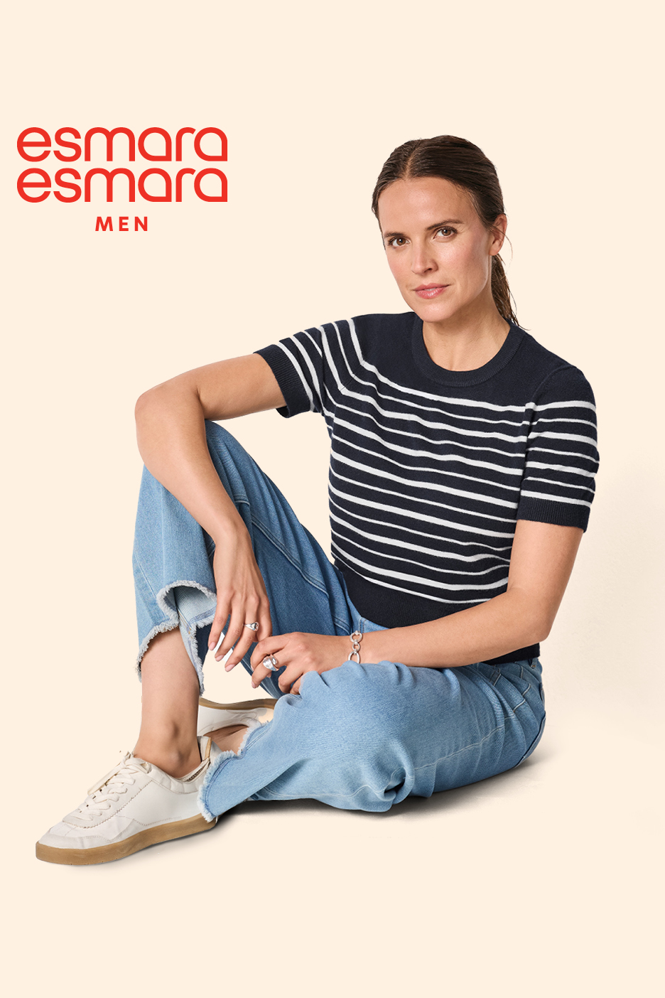 Žena u prugastoj majici i trapericama sjedi na podu, s natpisom 'esmara esmara MEN'.