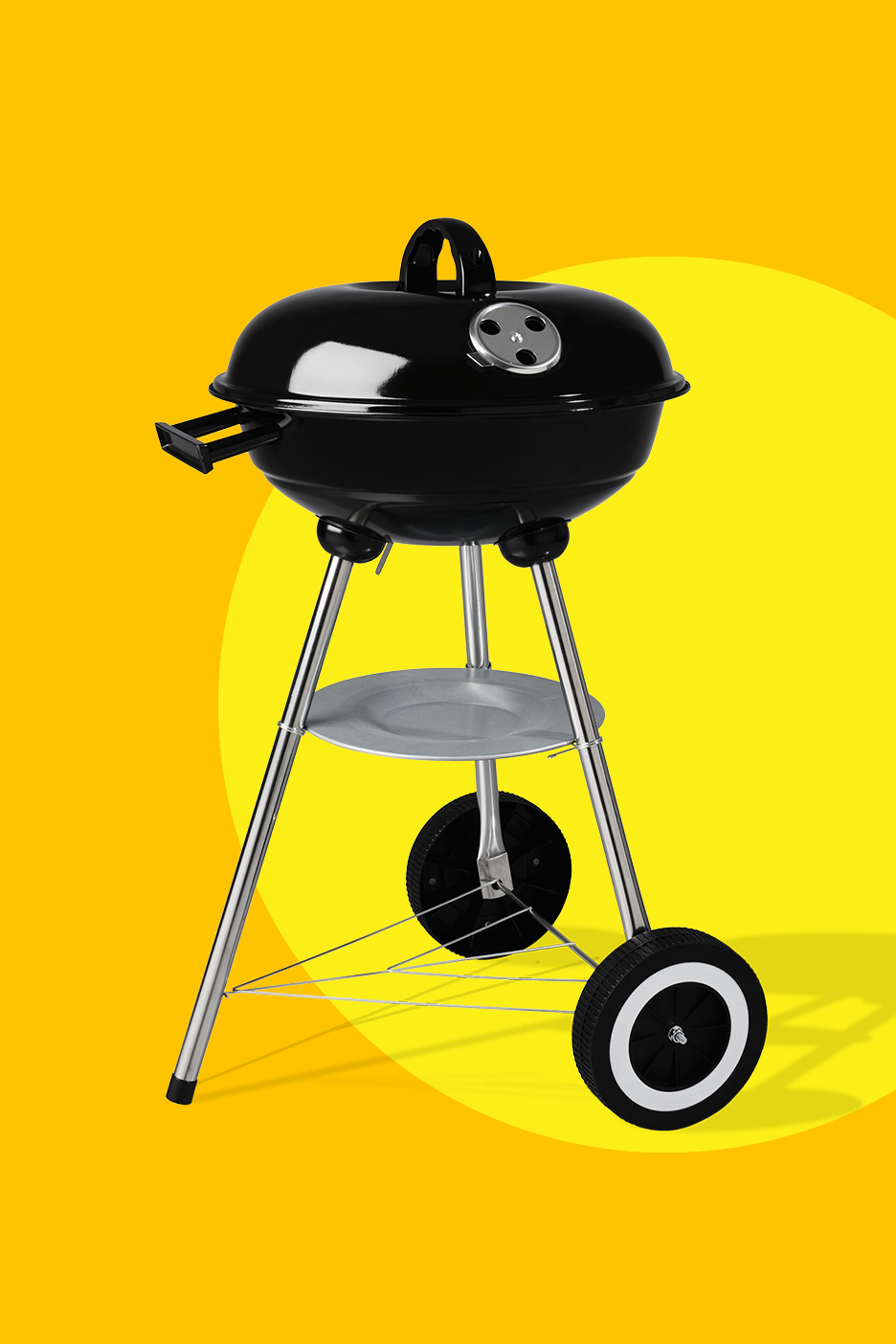 Crni roštilj na ugljen s kotačima na žutoj pozadini.