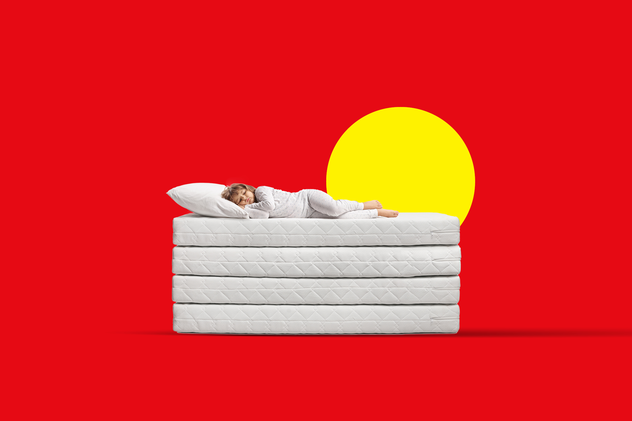 Djevojčica spava na hrpi madraca s jastukom na crvenoj pozadini sa žutim krugom.