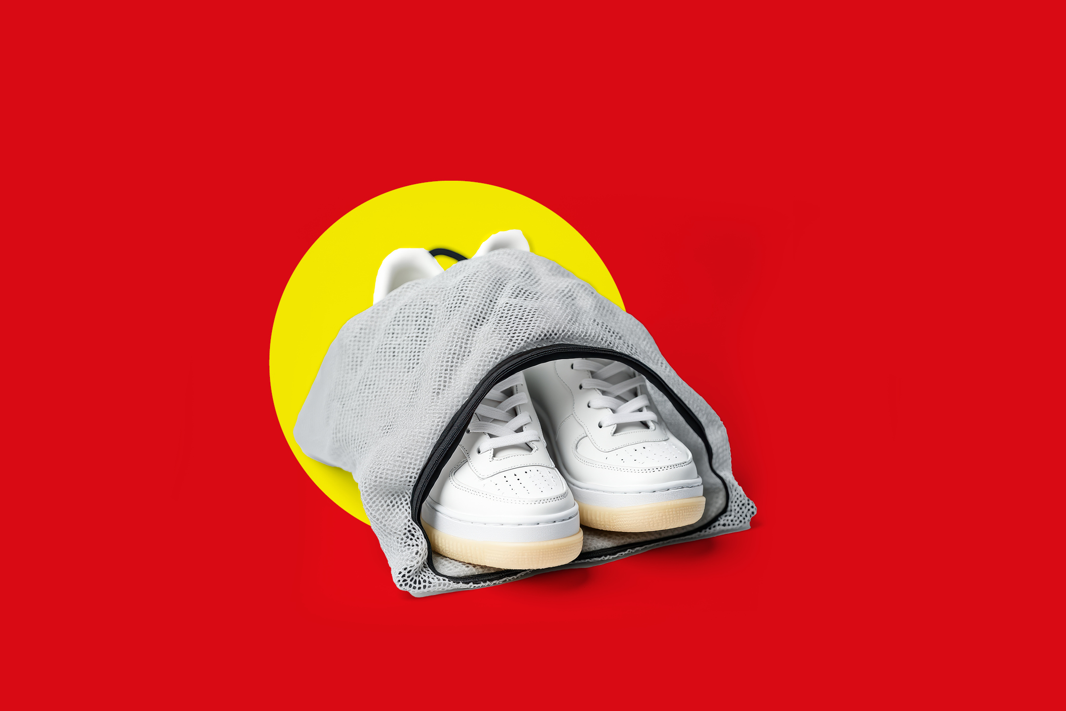 Bijele tenisice u mrežastoj vrećici za pranje na crvenoj pozadini sa žutim krugom.