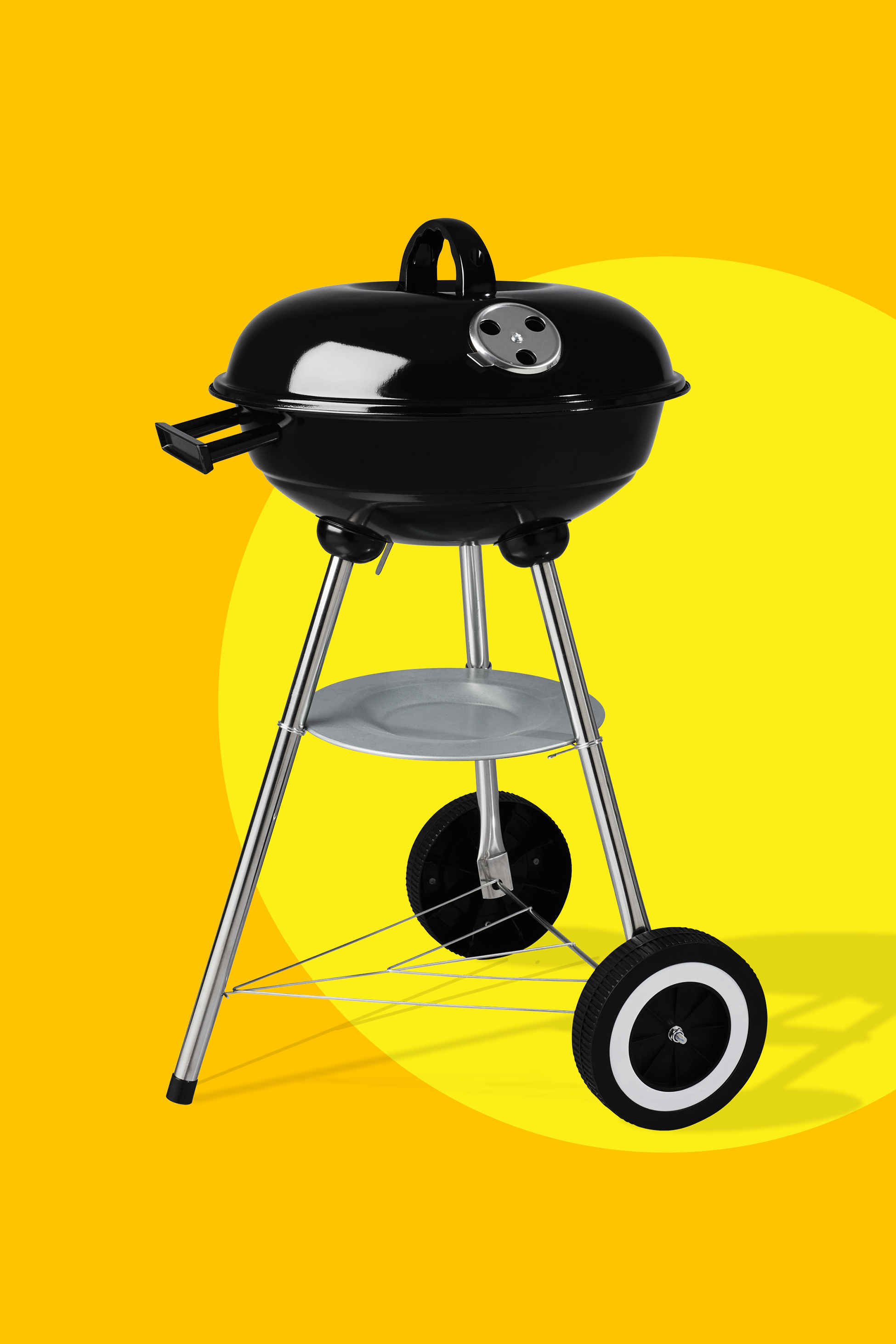 Crni roštilj na ugljen s kotačima na žutoj pozadini.