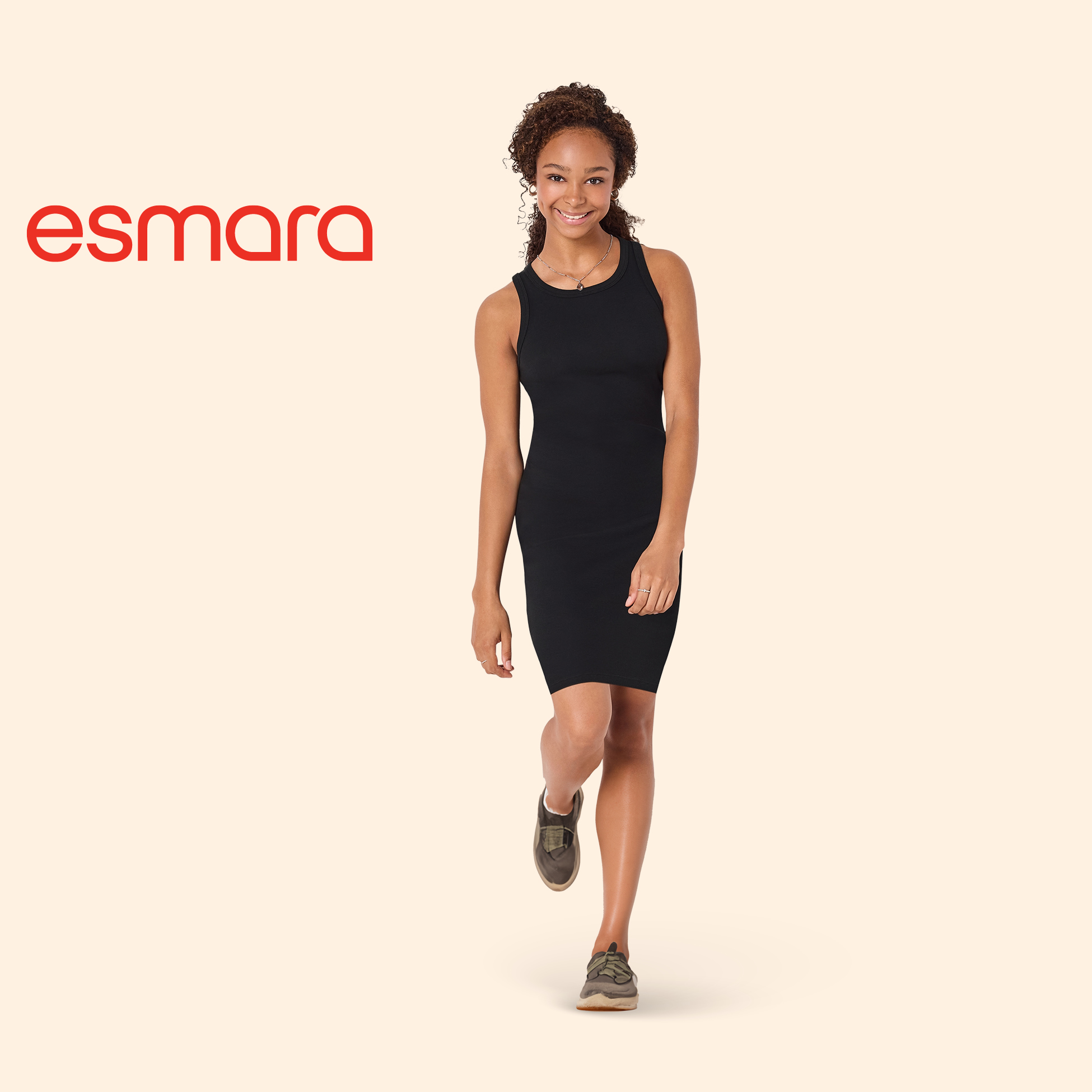 Žena u crnoj haljini bez rukava i tenisicama, s logotipom robne marke.