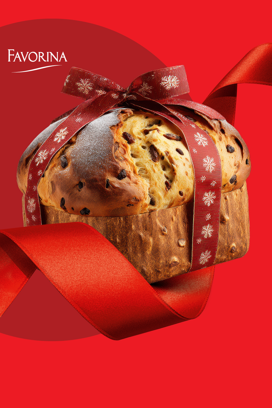 Favorina panettone kolač ukrašen crvenom vrpcom s motivom pahuljica.