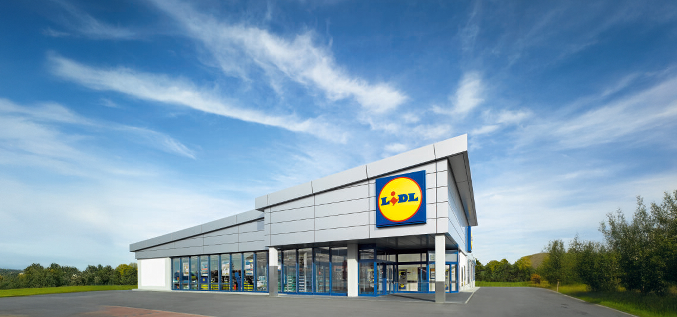 Moderna Lidl trgovina smještena u zelenom okolišu.