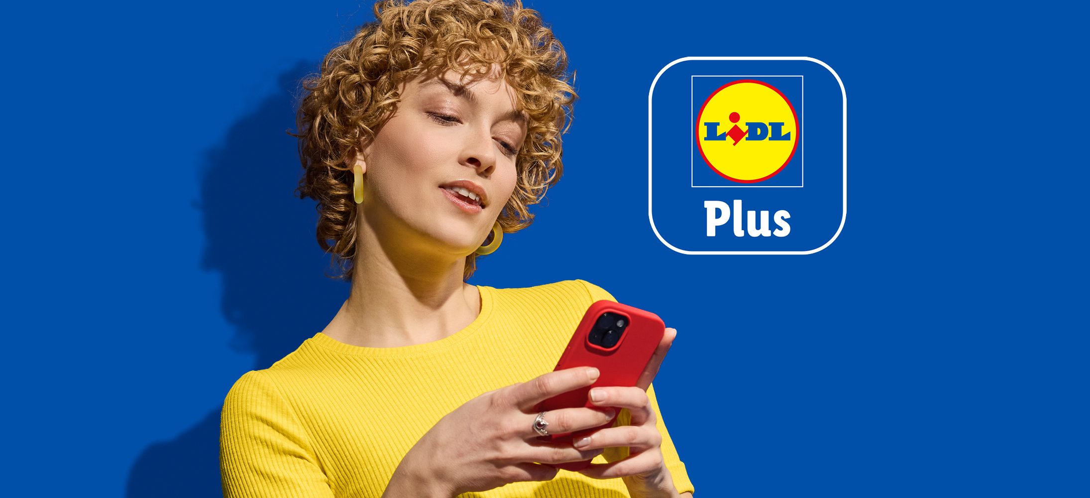 Žena gleda u mobitel s Lidl Plus logom