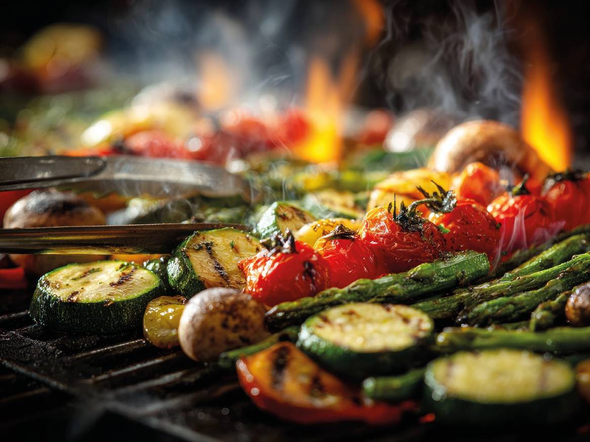 Povrće na žaru: tikvice, rajčice, šparoge i gljive s plamenom i dimom.
