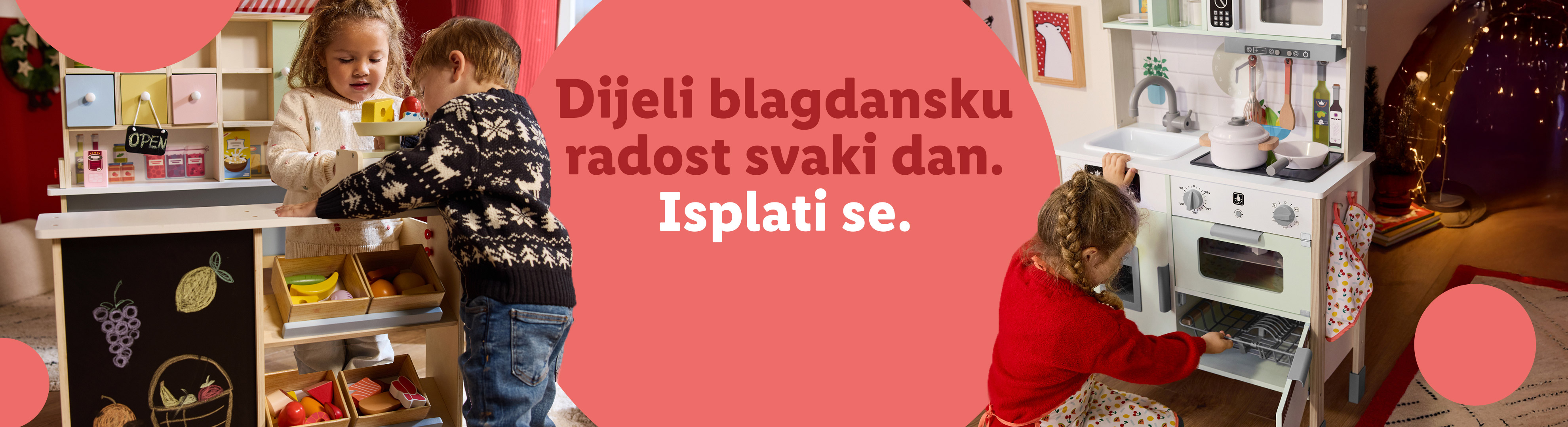 Dvoje djece igra se s drvenom kuhinjom i štandom s hranom, s tekstom: 'Dijeli blagdansku radost svaki dan. Isplati se.'