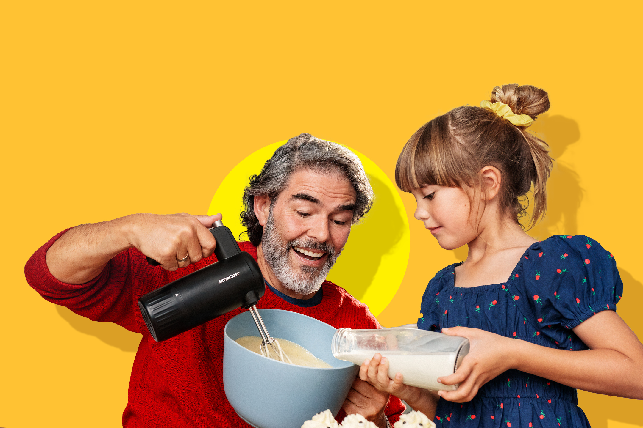 Otac i kći peku kolače, otac miksa tijesto, a kći dodaje mlijeko.