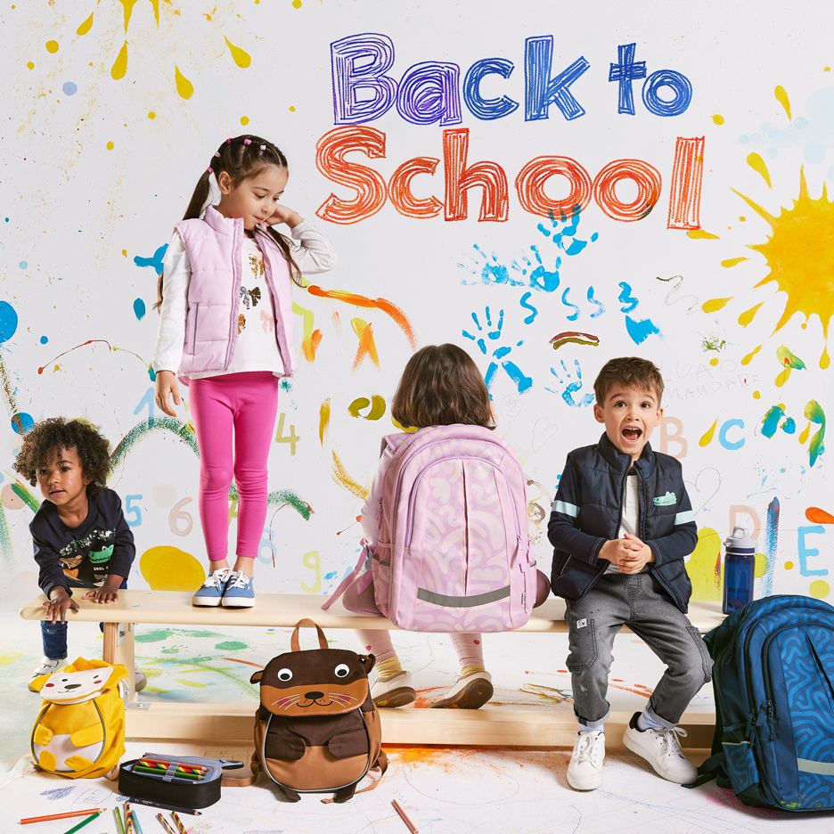 Četvero djece s ruksacima i školskim priborom, s tekstom „Back to School“ na šarenoj pozadini.
