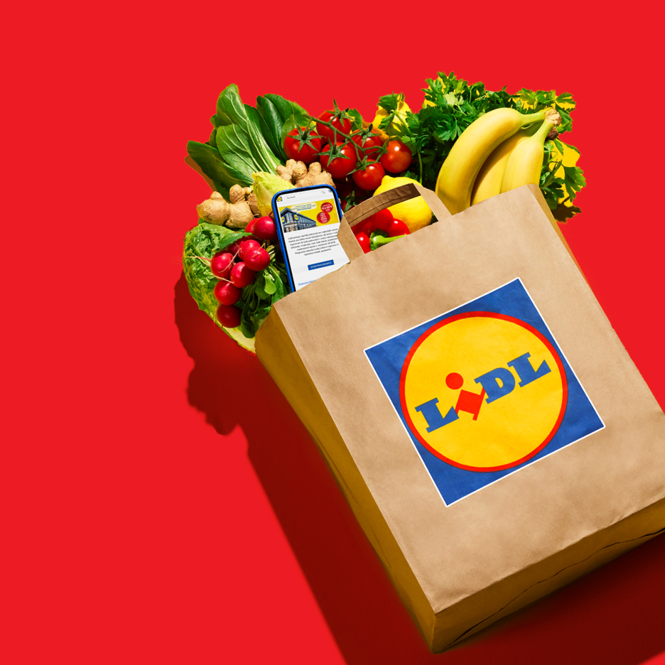 Lidl papirnata vrećica s namirnicama, uključujući banane, rajčice, rotkvice i mobitel s aplikacijom.