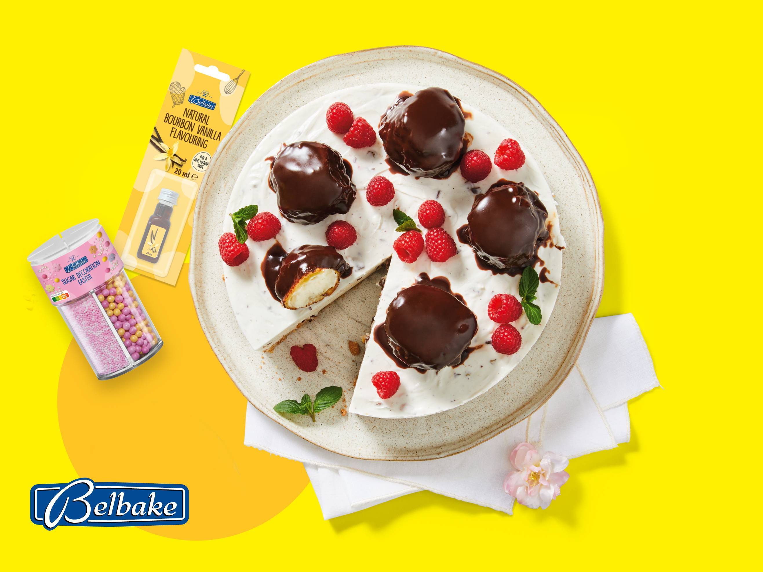 Torta s čokoladnim preljevom i malinama, uz arome vanilije i uskršnje šećerne ukrase.