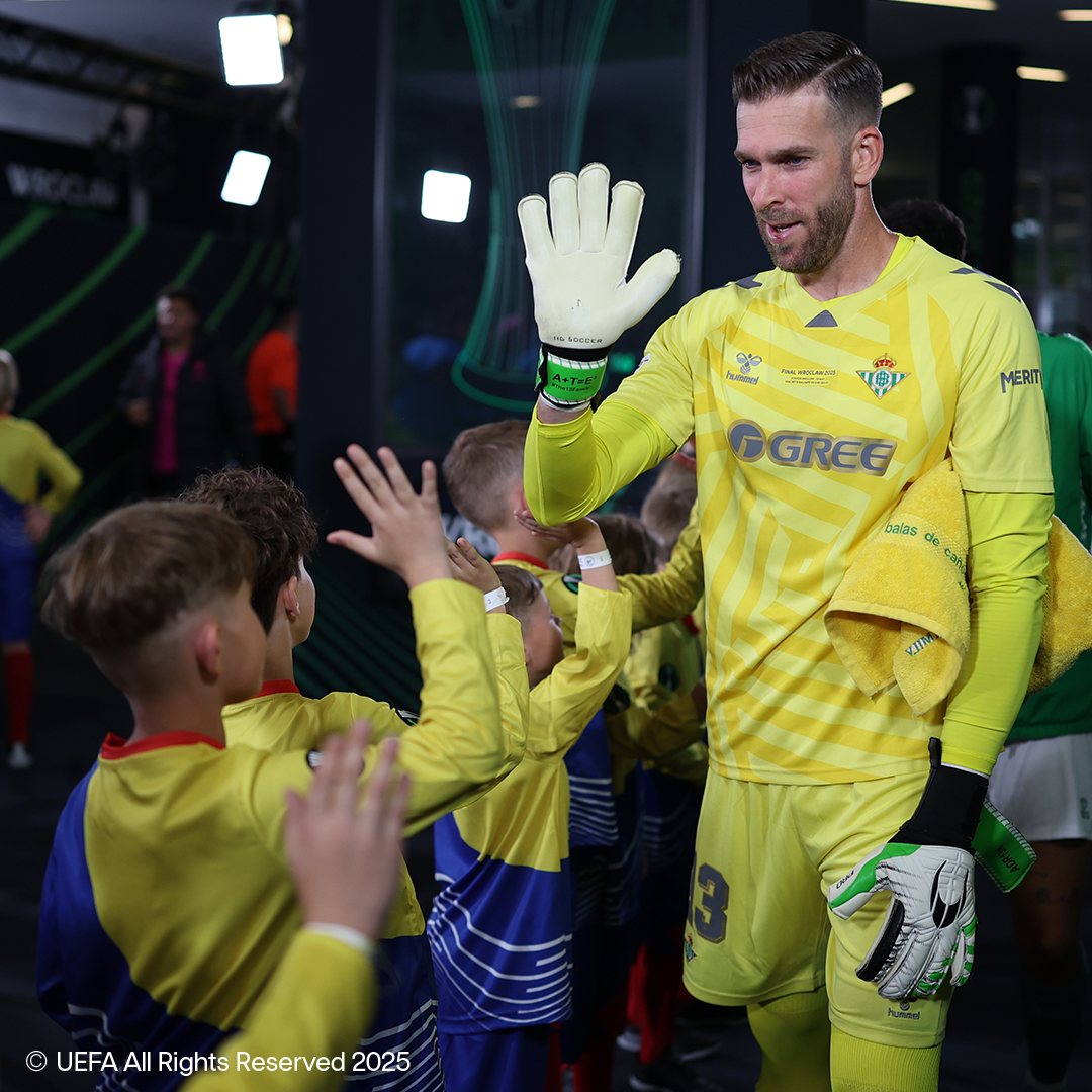 Nogometni vratar u žutom Hummel dresu s HG Soccer rukavicama pozdravlja djecu.