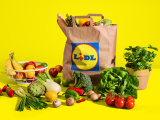 Lidl papirnata vrećica s namirnicama i svježim voćem i povrćem na žutoj pozadini.