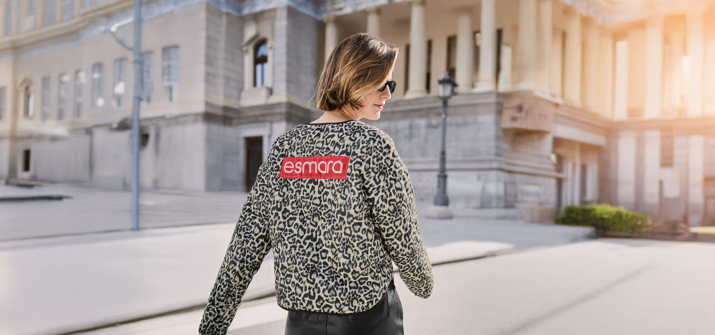 Žena u Esmara jakni s leopard uzorkom, sunčanim naočalama, na gradskoj ulici.