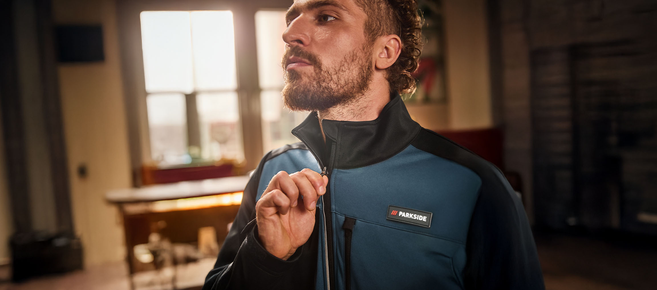 Muškarac u plavo-crnoj Parkside radnoj jakni zakopčava je