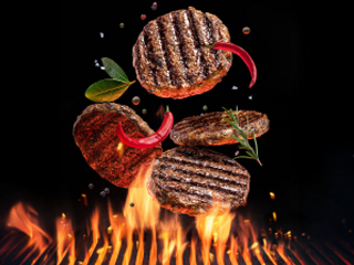 Sokočne pljeskavice za hamburger lete iznad žara.
