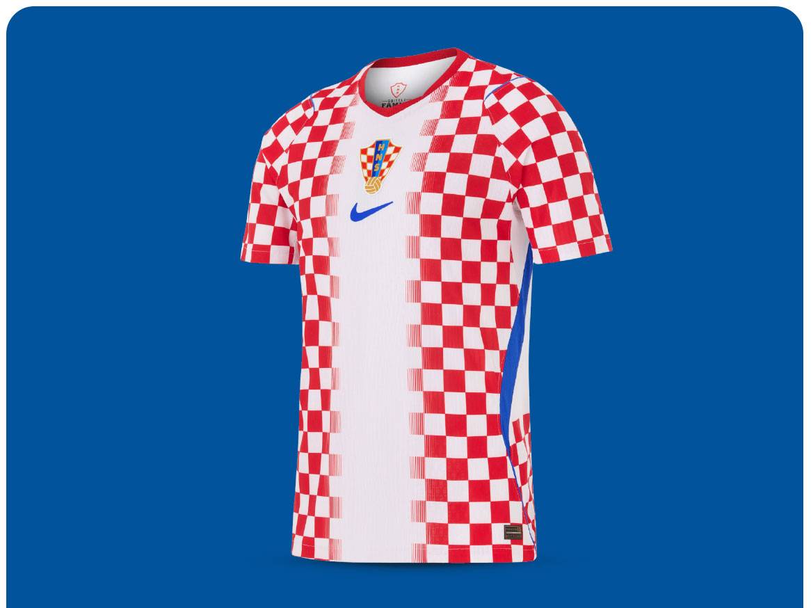 Bijela i crvena karirana nogometna majica s plavim detaljima i grbom.