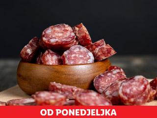 Narezana salama u drvenoj zdjeli i rasuta po drvenoj dasci, s crvenim natpisom 'OD PONEDJELJKA' na dnu.